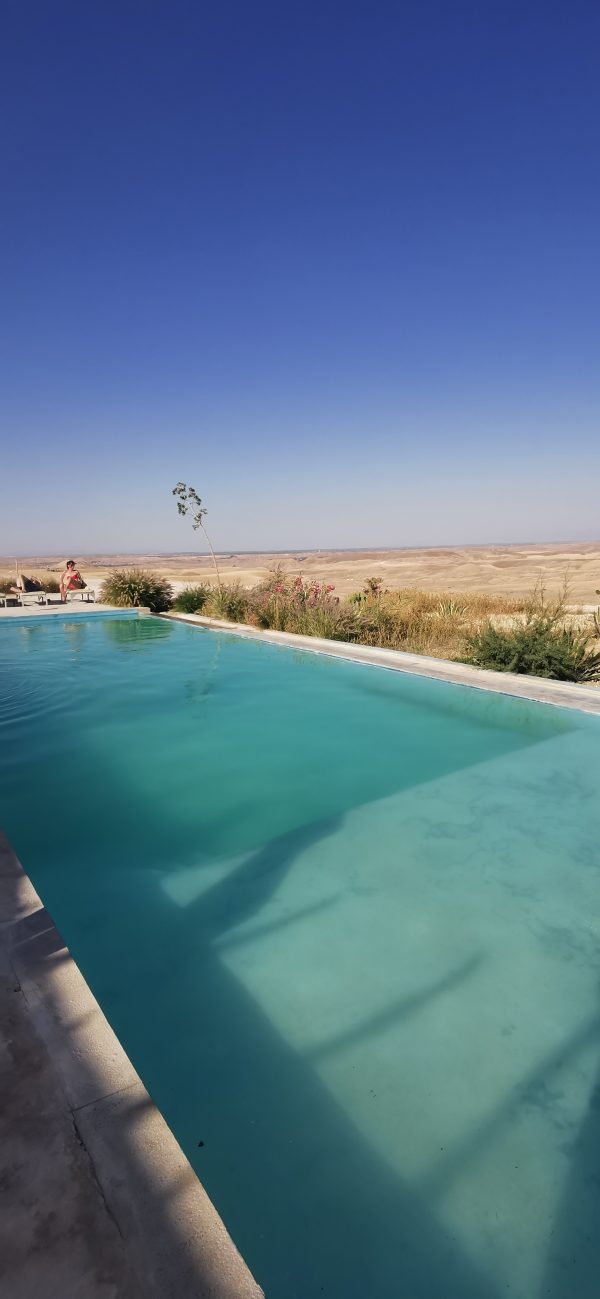 Piscine face au désert sous un ciel bleu